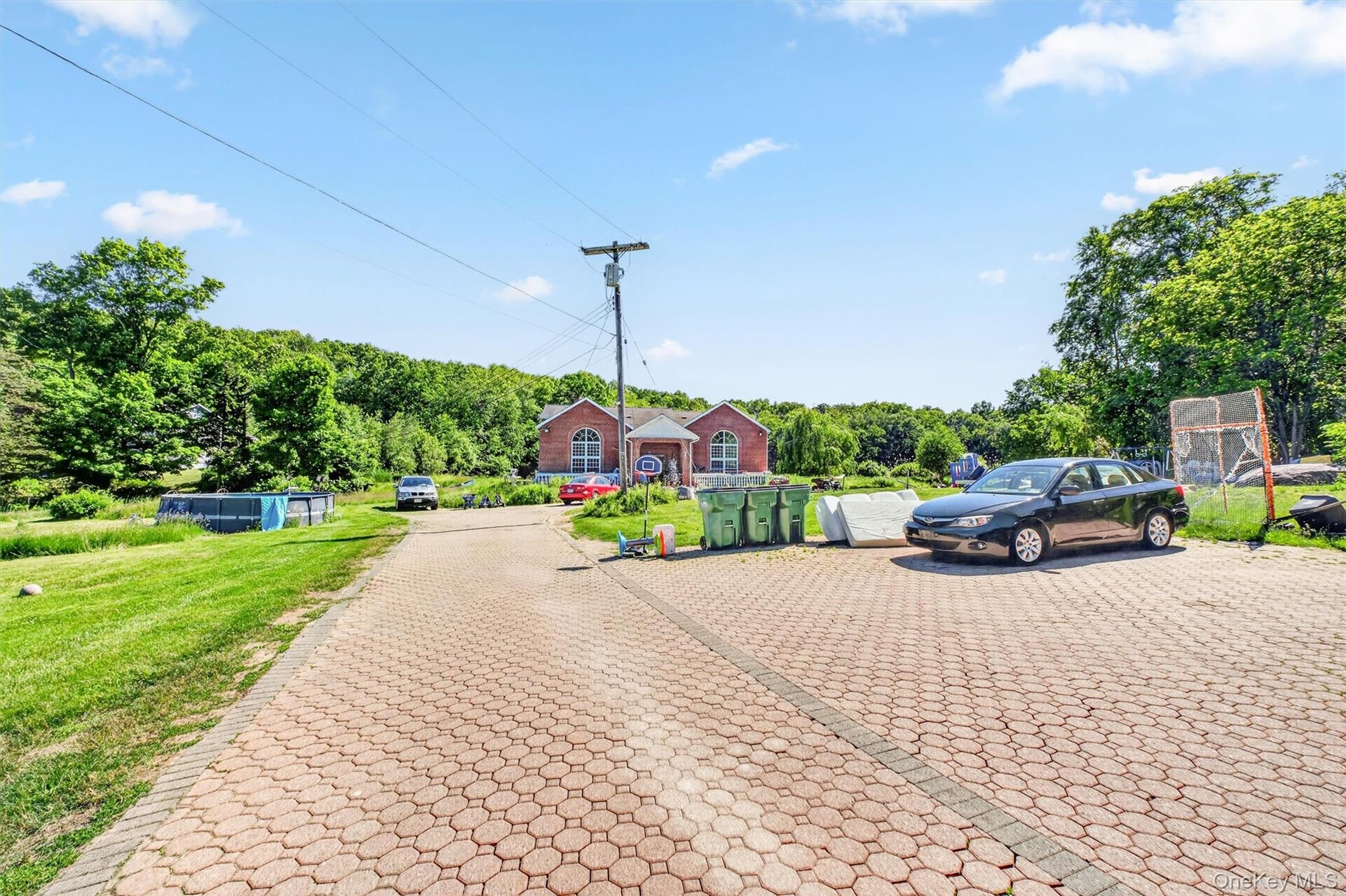 The expansive parking area in front of the home offers ample space for multiple vehicles and a variety of additional uses.