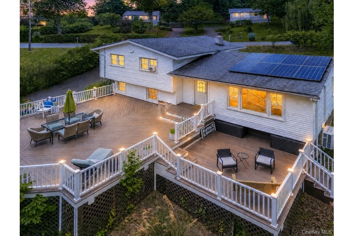 Multi-level outdoor deck featuring recessed lighting, white railings, and a large dining area