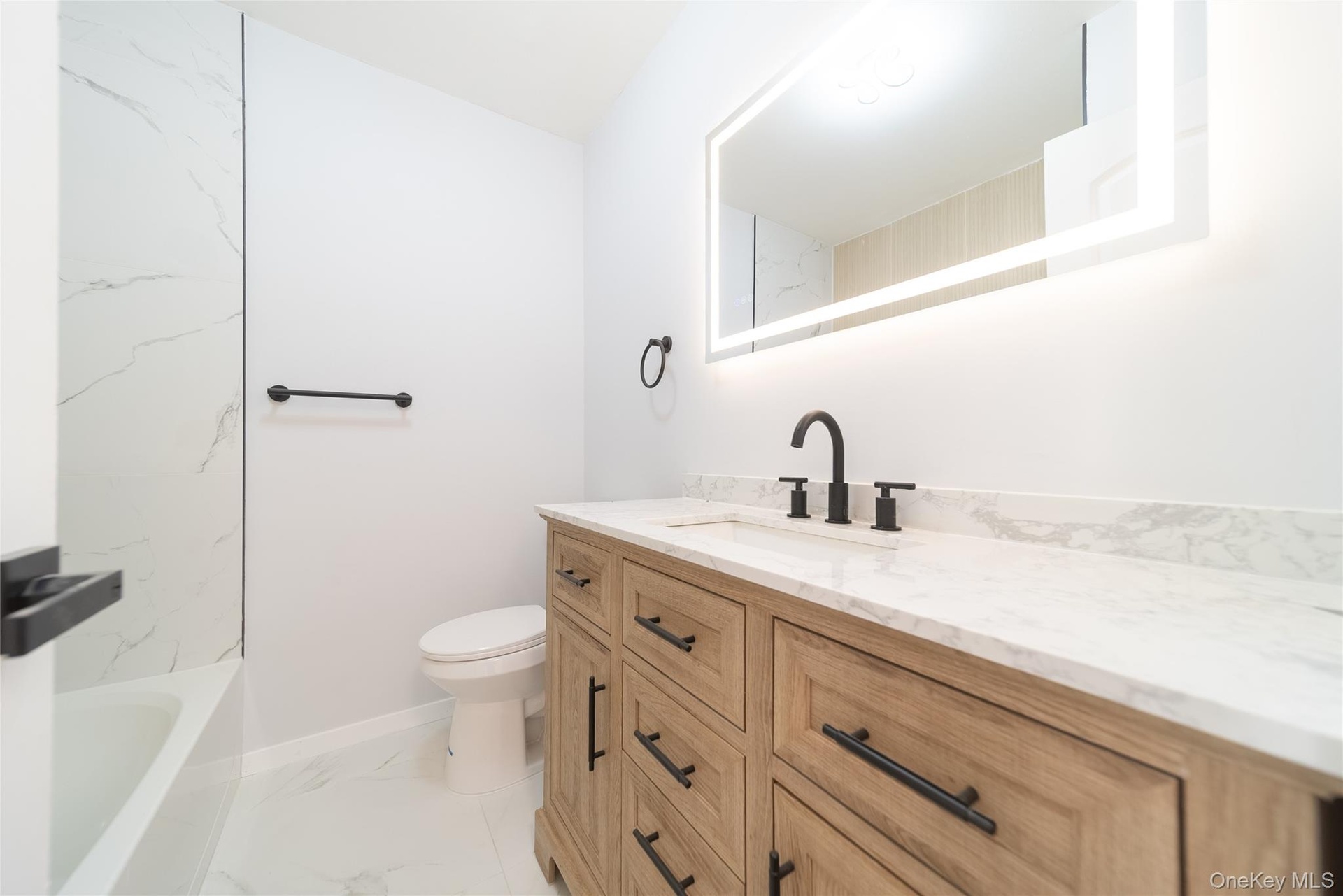 Bathroom with vanity and light marble finish floors