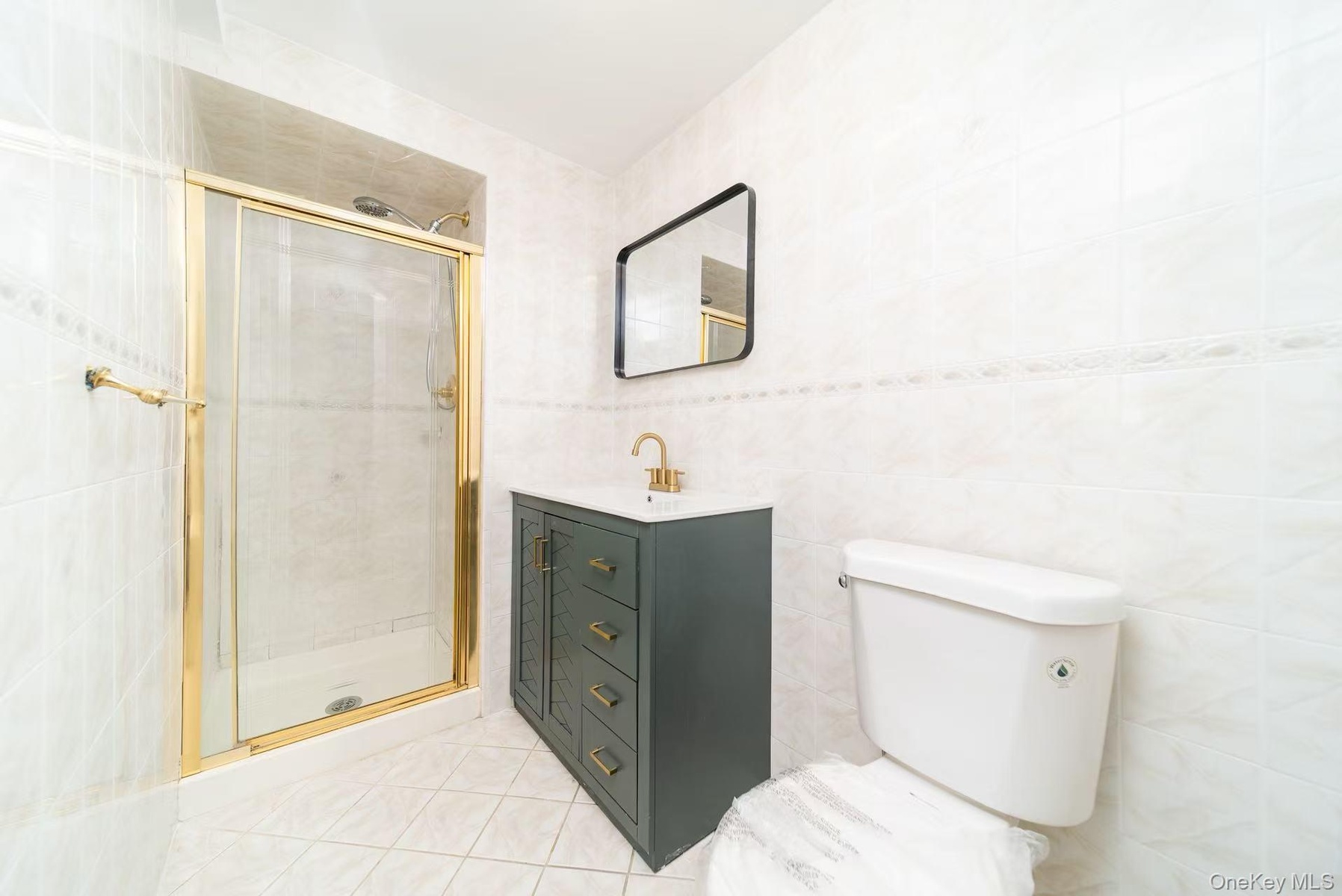 Bathroom featuring tile walls, a stall shower, vanity, and light tile patterned floors