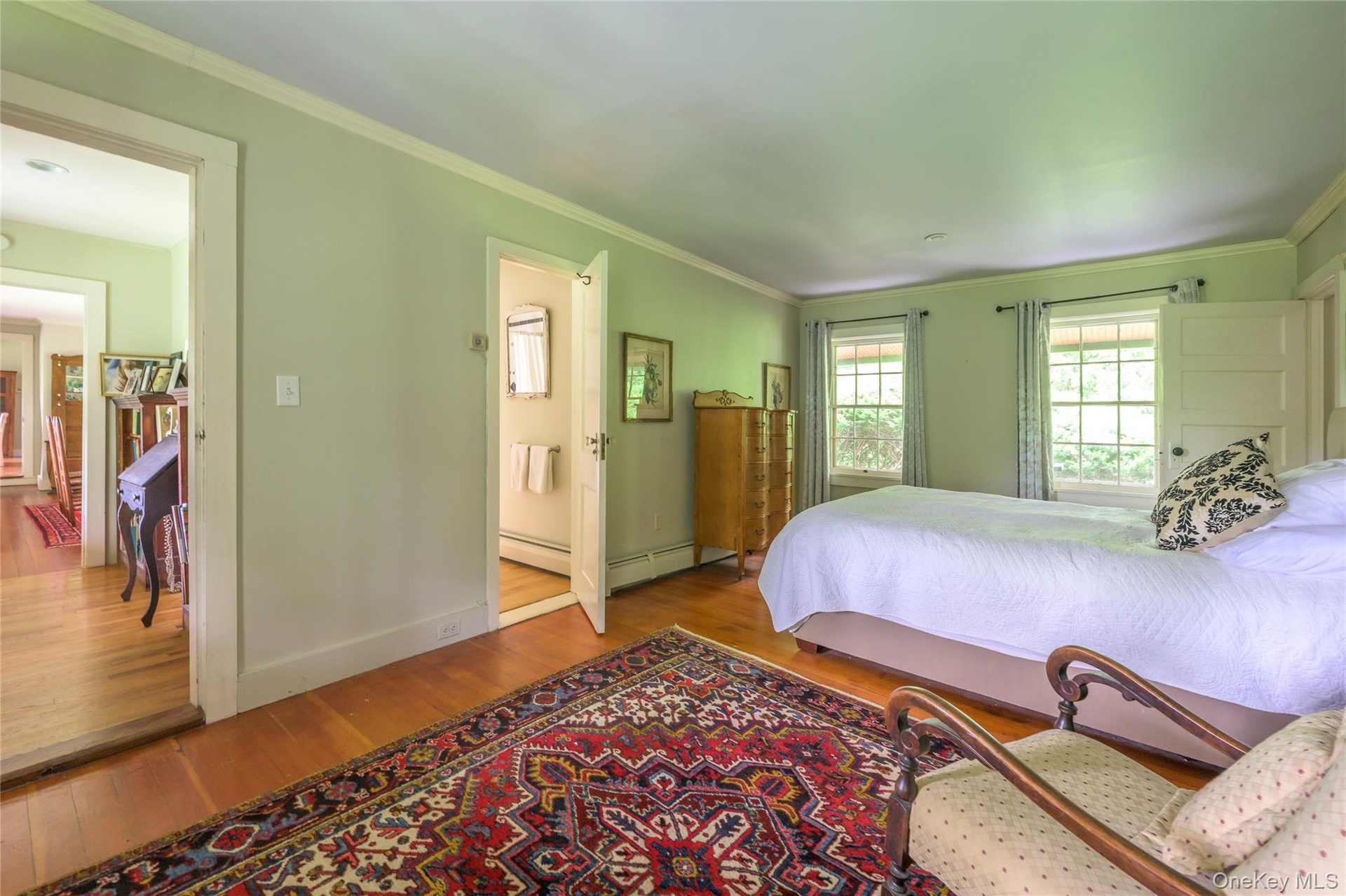 Bedroom with wood finished floors and ornamental molding