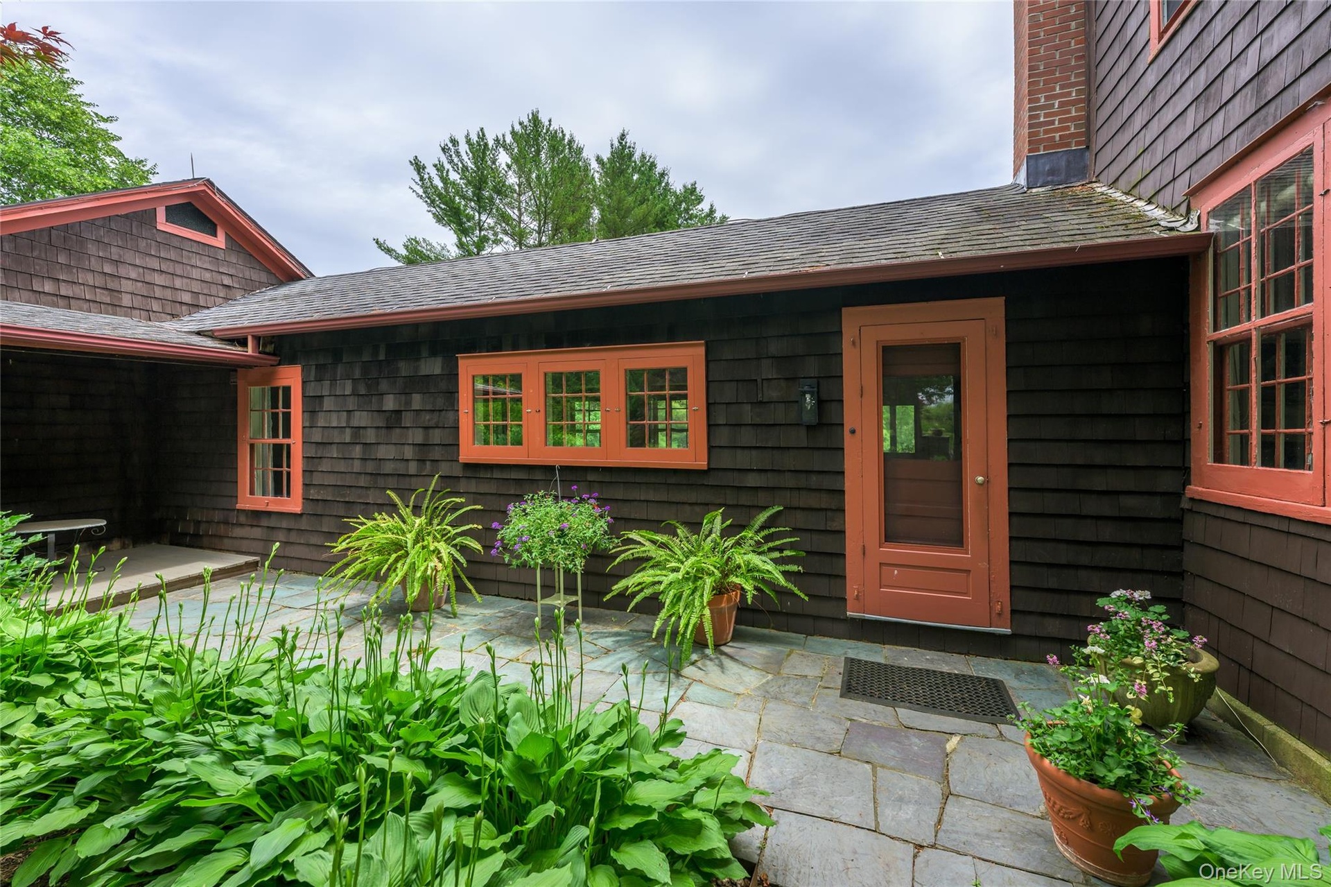 Doorway to property featuring a patio area and a chimney