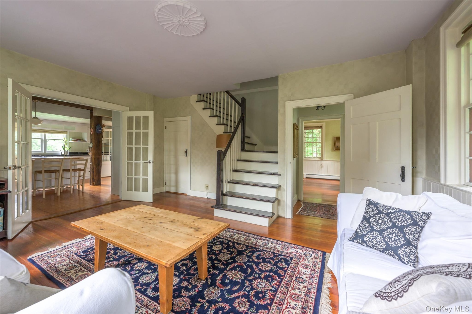 Living room featuring french doors, wood finished floors, stairs, and healthy amount of natural light