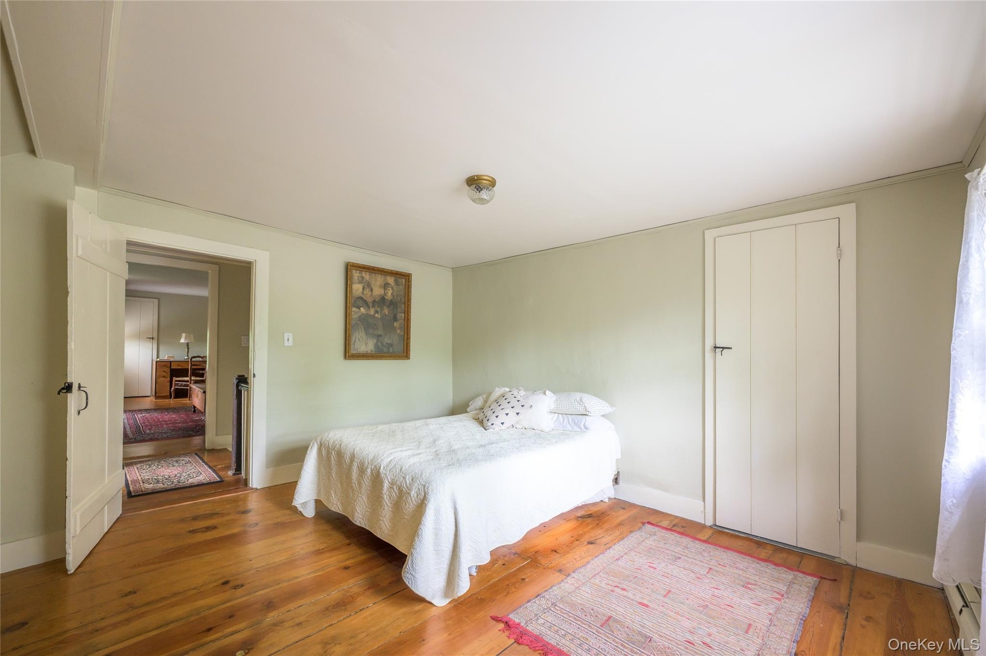 Bedroom with hardwood / wood-style flooring and baseboards