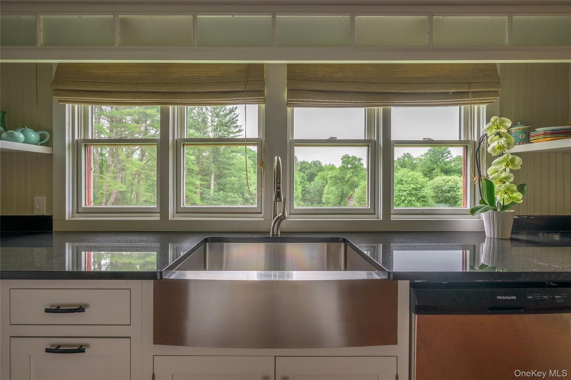 Kitchen with dishwasher, white cabinetry, and dark stone counters