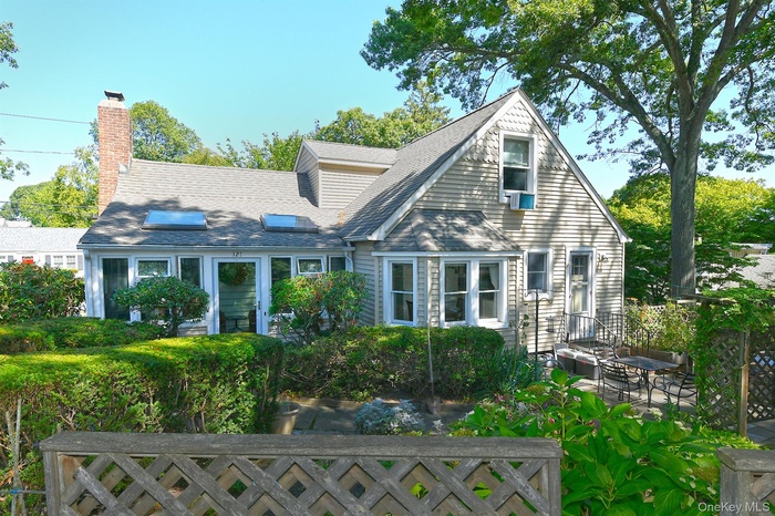 View of house featuring a chimney and roof with shingles