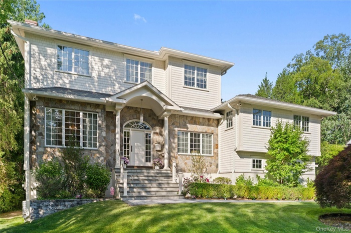 Stone and shingle colonial with covered entry portico