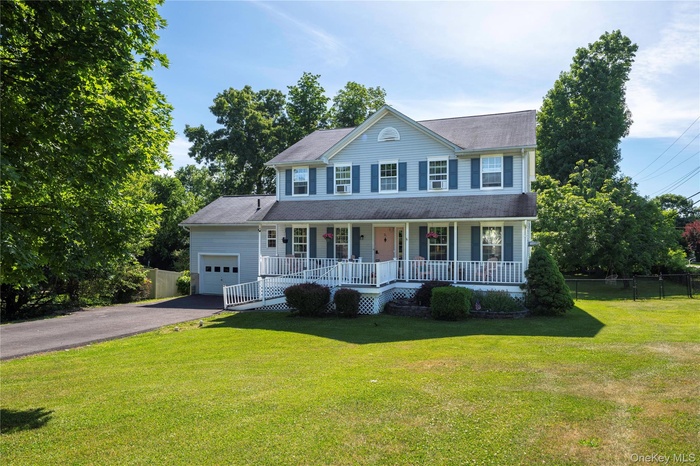 Two-story residence featuring light blue siding, a covered front porch with white railing, and an attached single-car garage