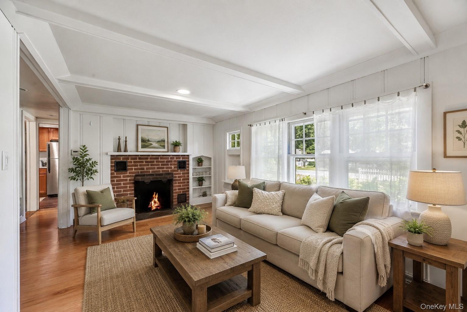 Inviting living room featuring hardwood floors, abundant natural light and a classic fireplace.
