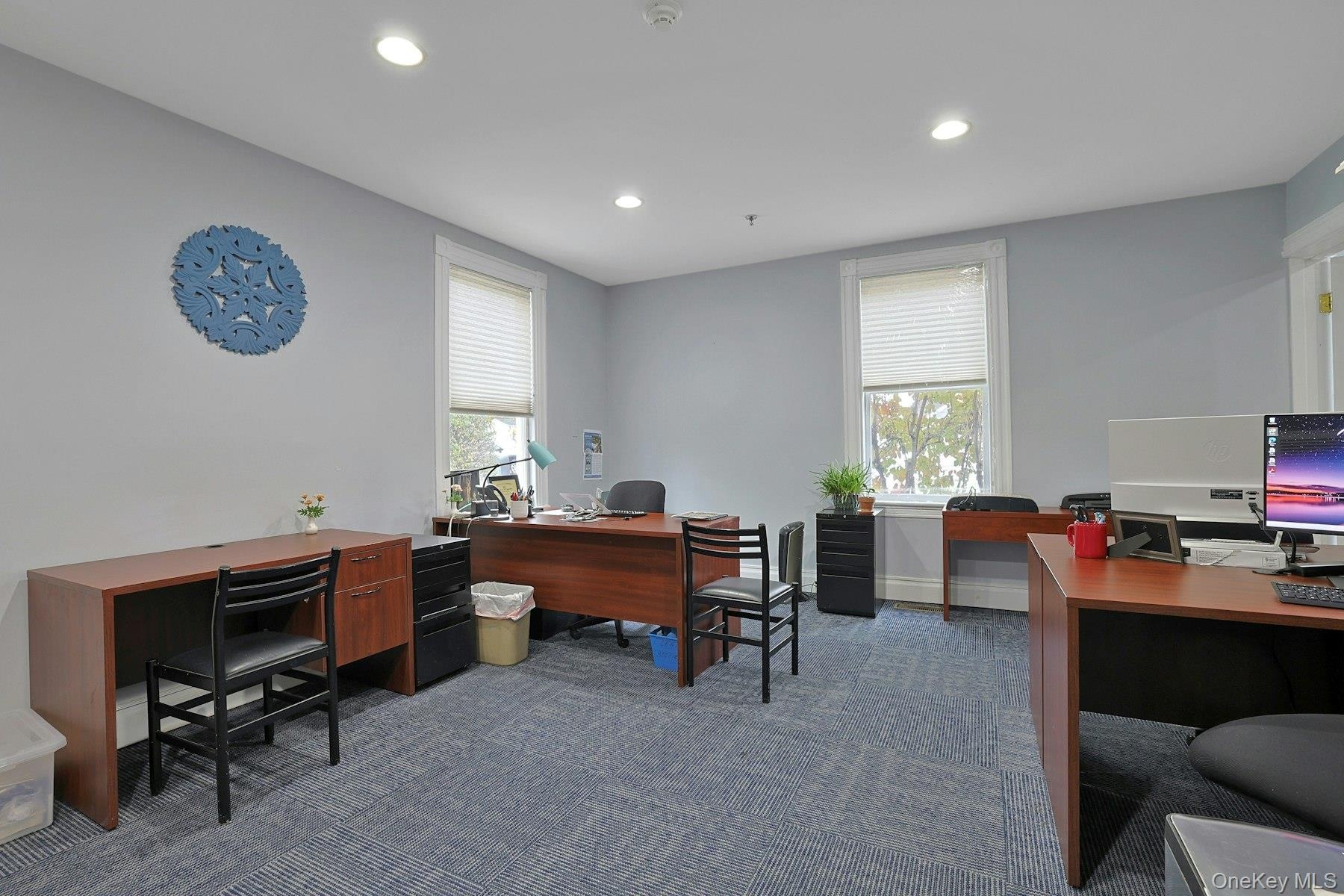 Home office with dark carpet and recessed lighting