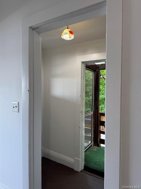 Delightful mud room between kitchen & back porch featuring cathedral ceiling & window facing sunporch.