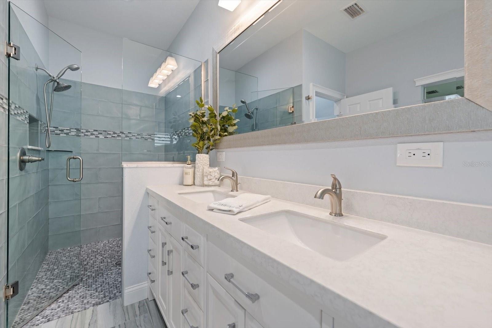 Spa like primary bath with walk in shower and attractive finishings