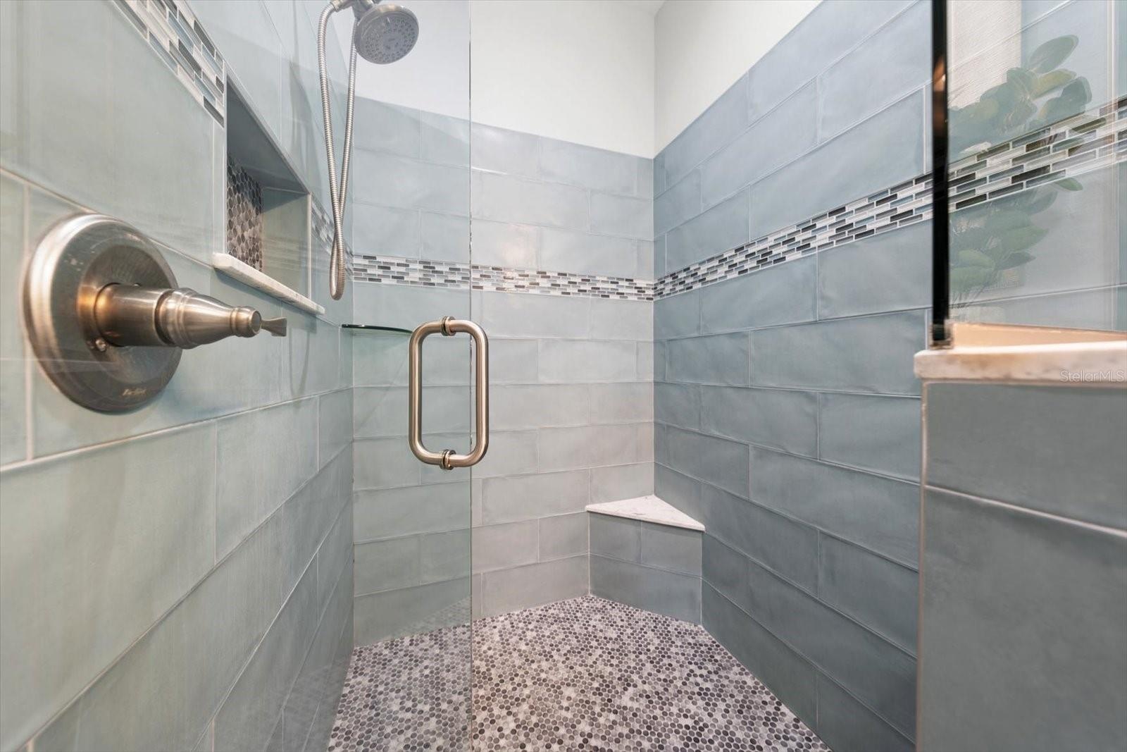 Walk in shower in primary bedroom suite bath area.