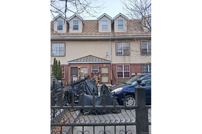 View of front facade featuring brick siding and a fenced front yard