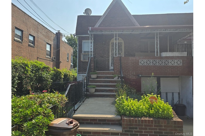 View of front facade with brick siding and a porch