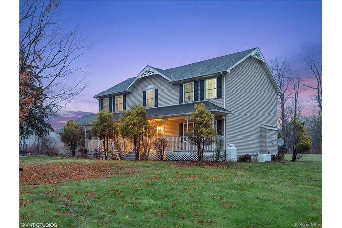 View of front facade featuring a yard and covered porch