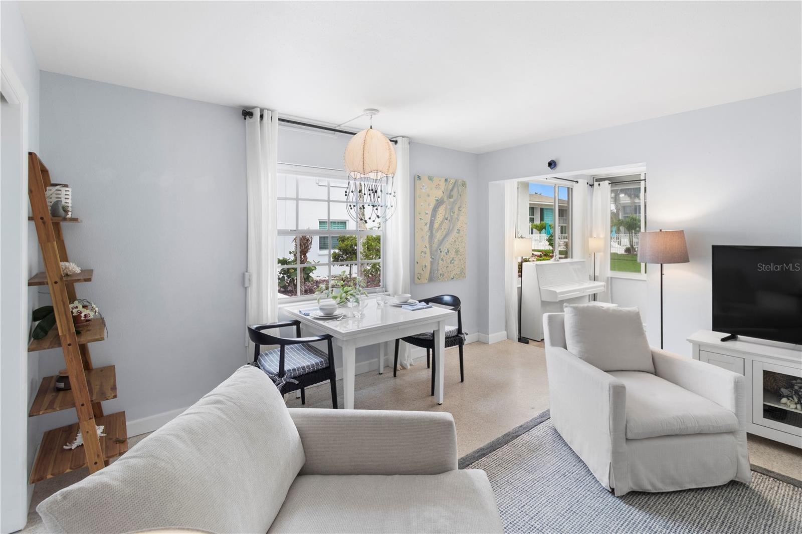 View of dining area and sun room (piano not included) from living room