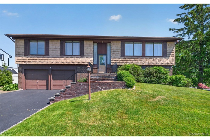Split-level home featuring cedar shake siding and a brown trim