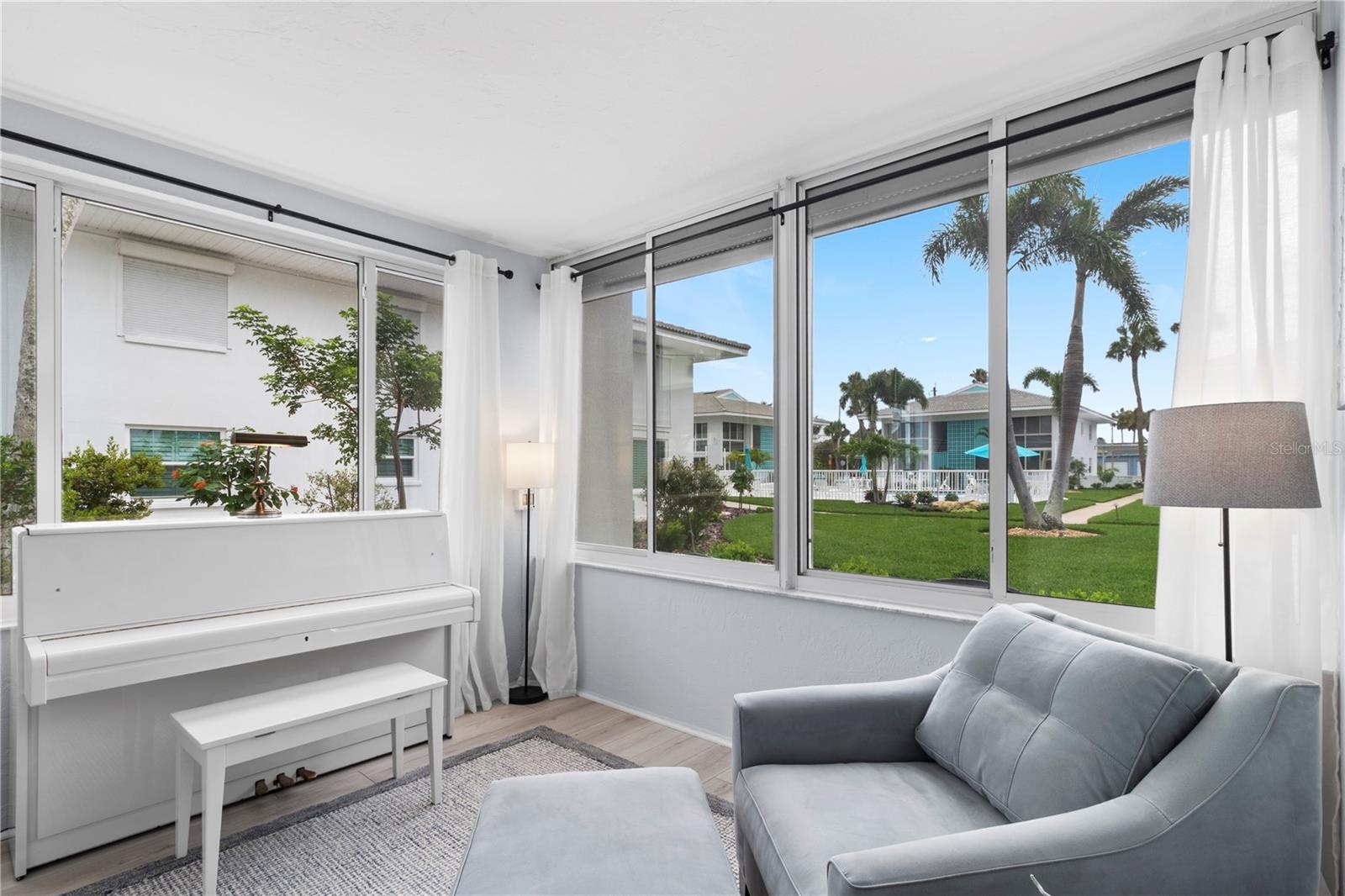 View of sunroom overlooking the courtyard and the heated courtyard swimming pool.  Yes, 2 heated pools in the community.
