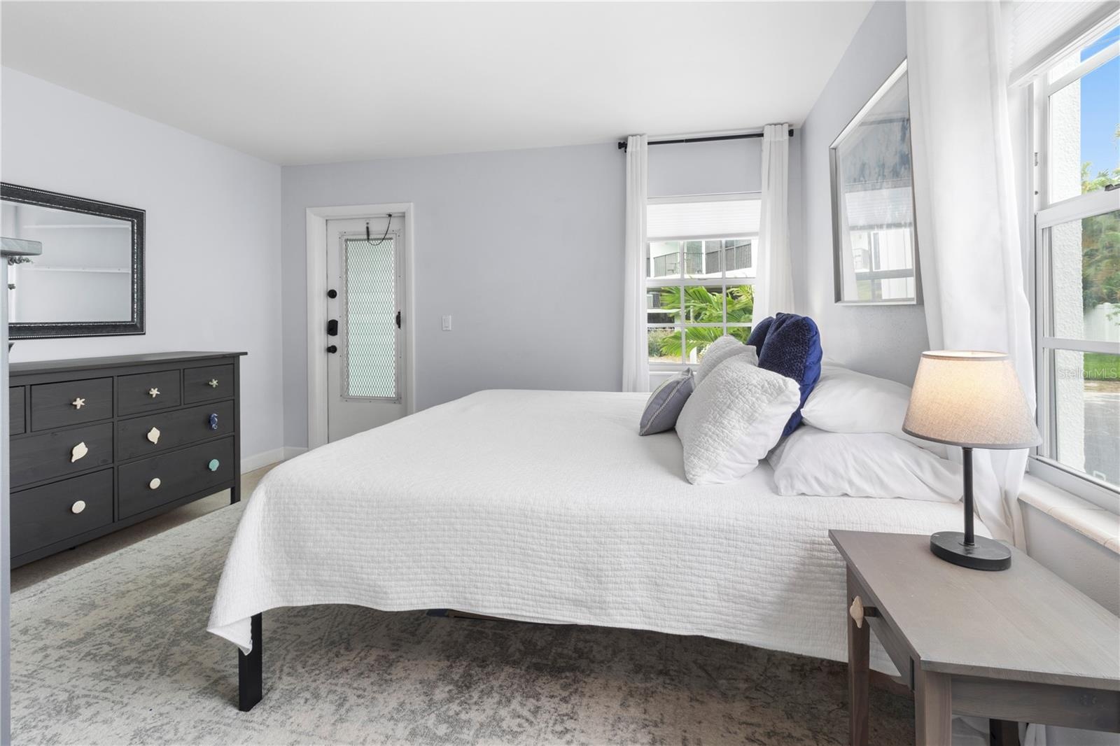 Primary Bedroom with back door exit (for safety) of the condo leading to private outdoor storage closet.