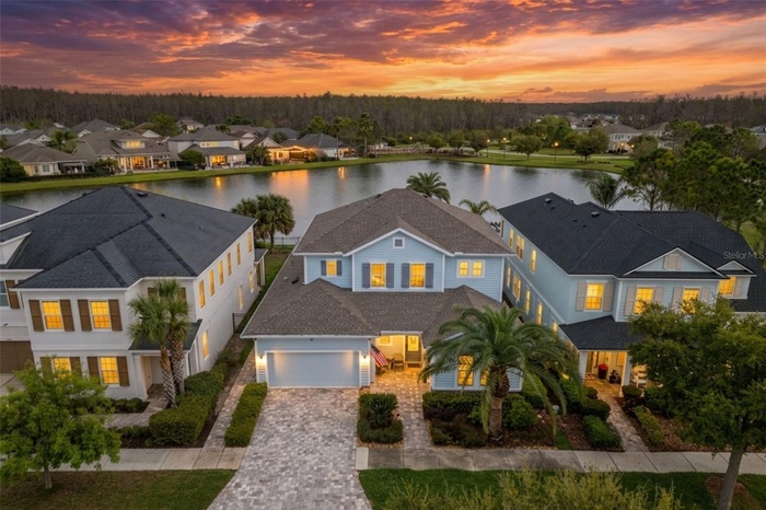 Former Asturia model home with extensive builder upgrades, a first-floor primary suite, pool and spa, outdoor kitchen, and peaceful pond views.