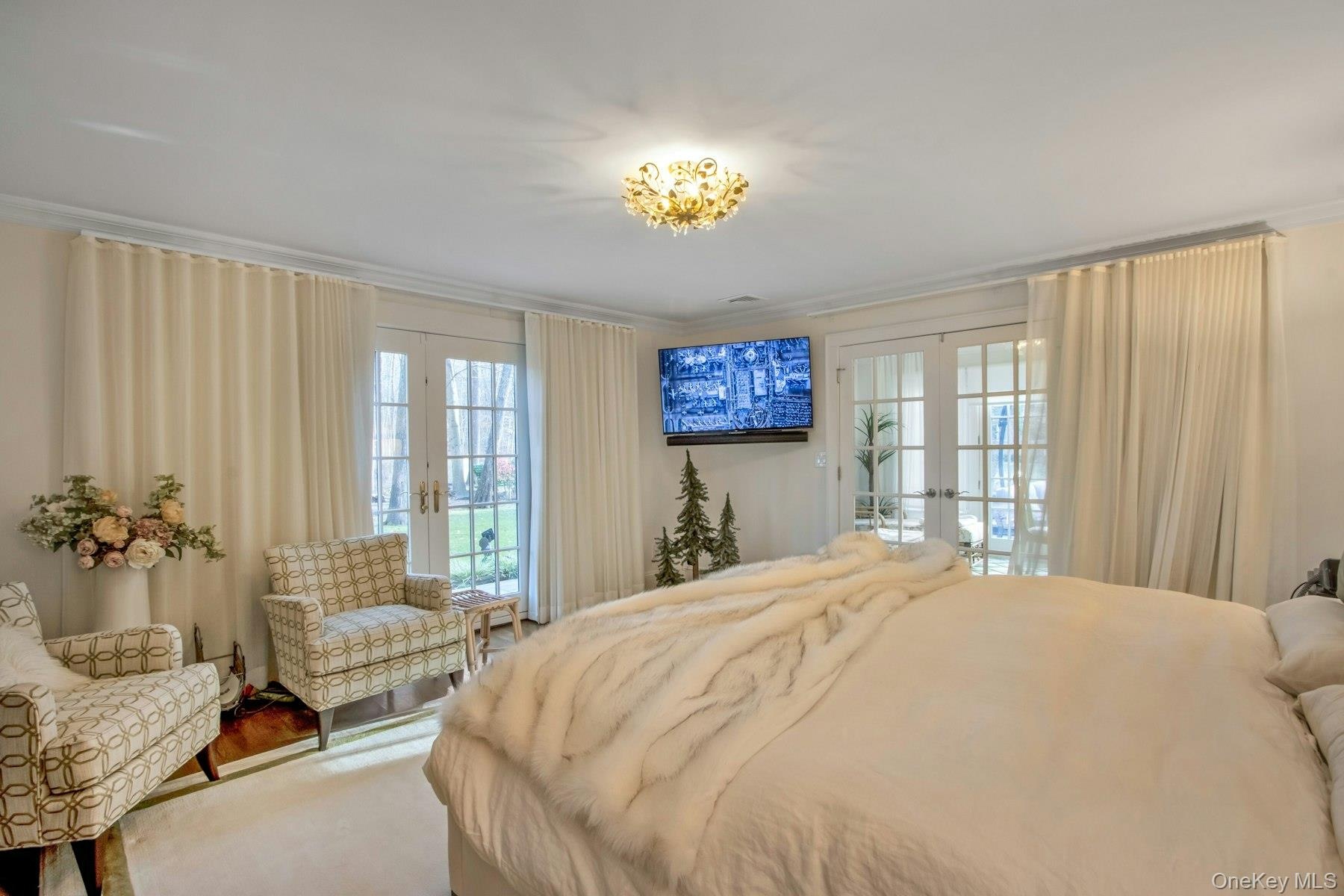Bedroom with access to exterior, french doors, multiple windows, and ornamental molding