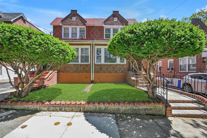 Brick facade residence featuring a red-tiled roof and multiple windows