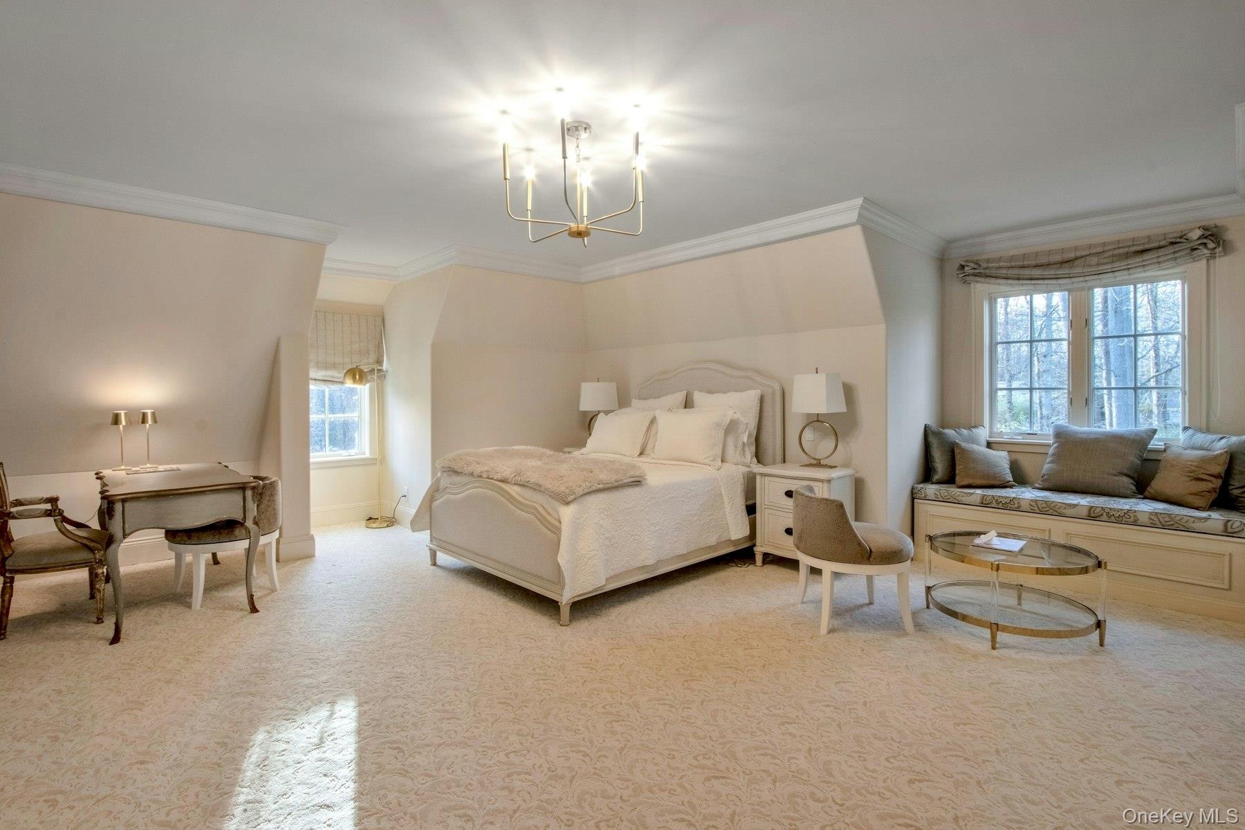 Carpeted bedroom featuring a notable chandelier and ornamental molding