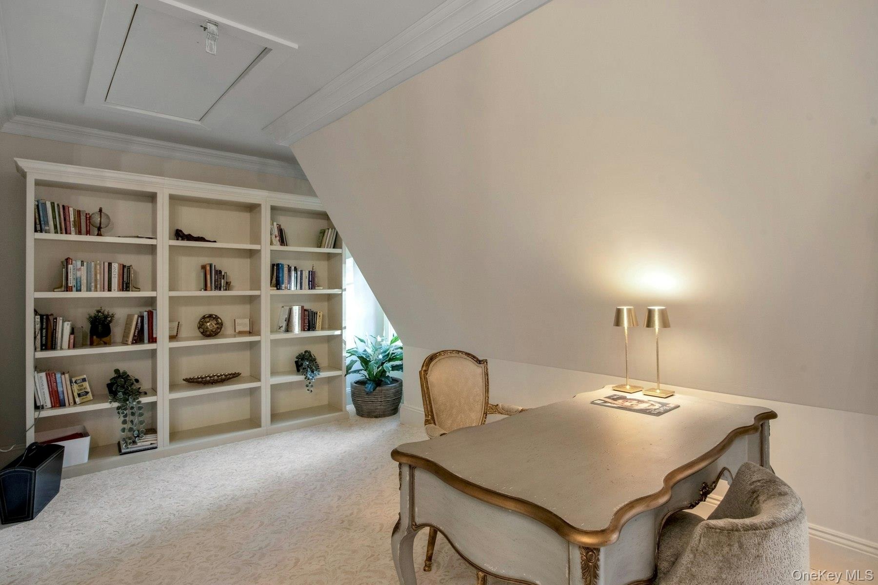 Carpeted office with lofted ceiling and ornamental molding