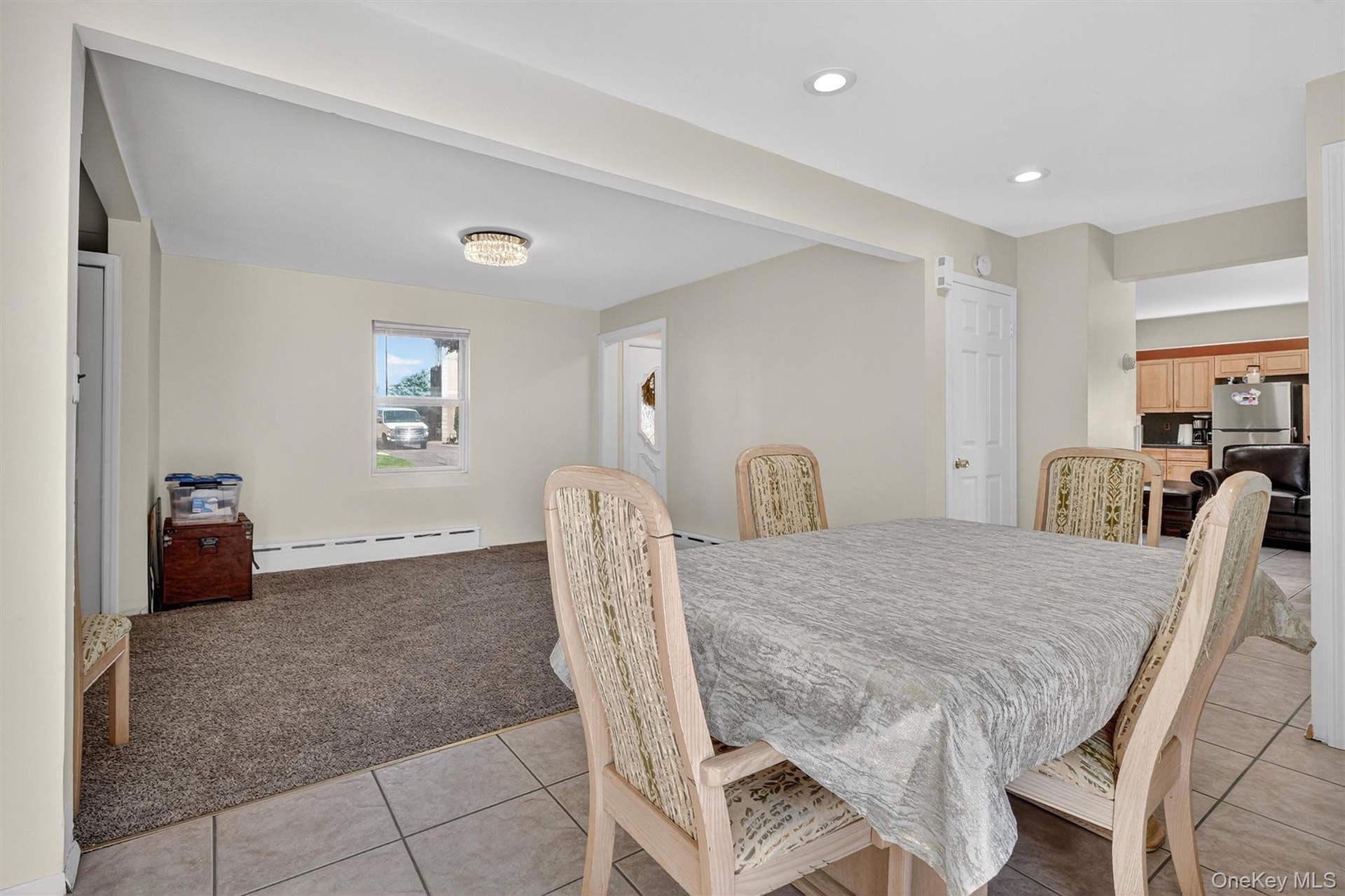 Dining space featuring light colored carpet, a baseboard heating unit, light tile patterned floors, and recessed lighting