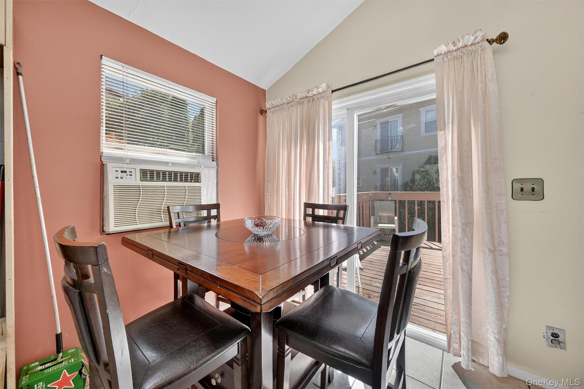 Dining space featuring lofted ceiling, light tile patterned flooring, and cooling unit