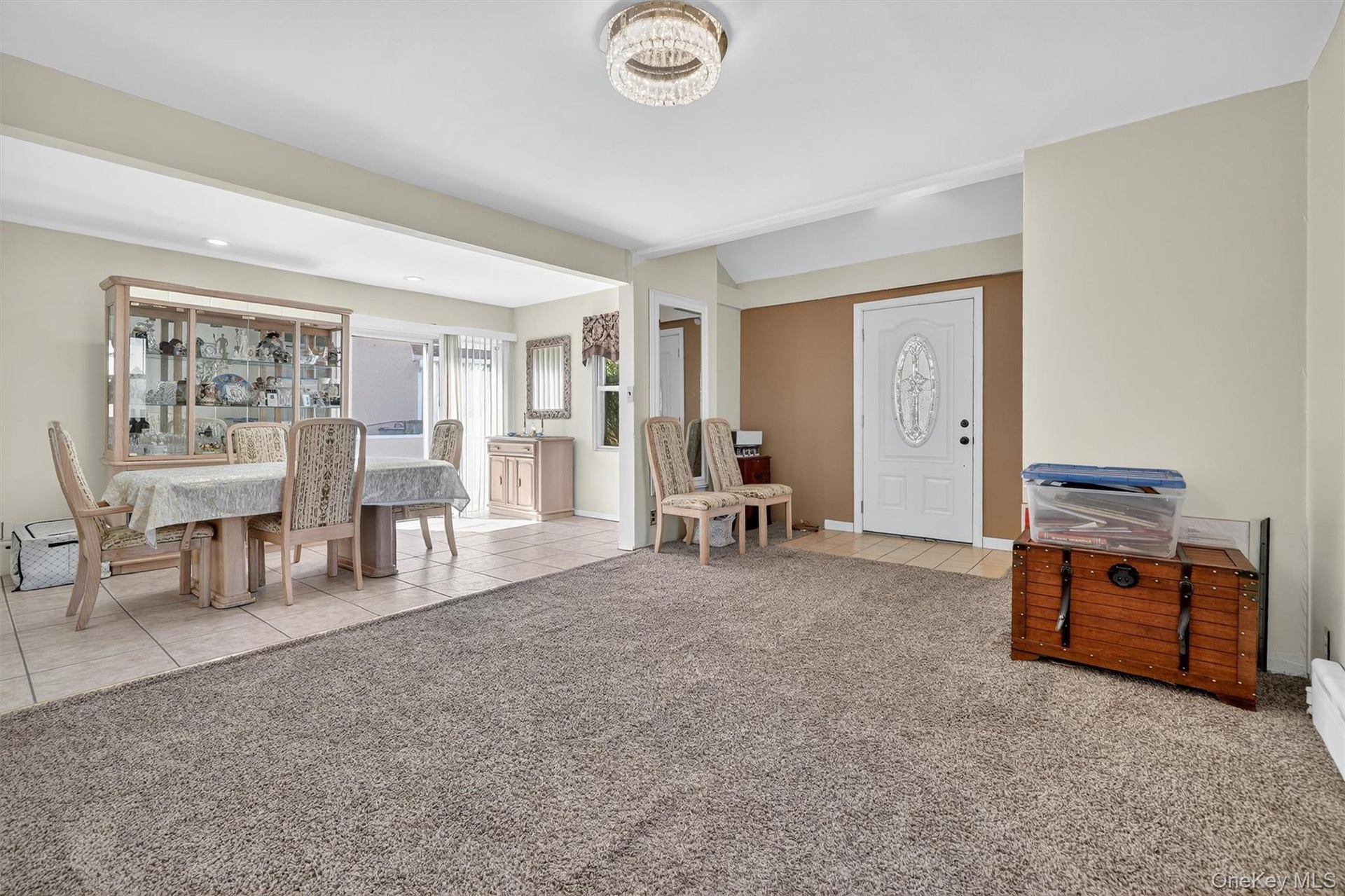 Foyer featuring light tile patterned flooring and light colored carpet