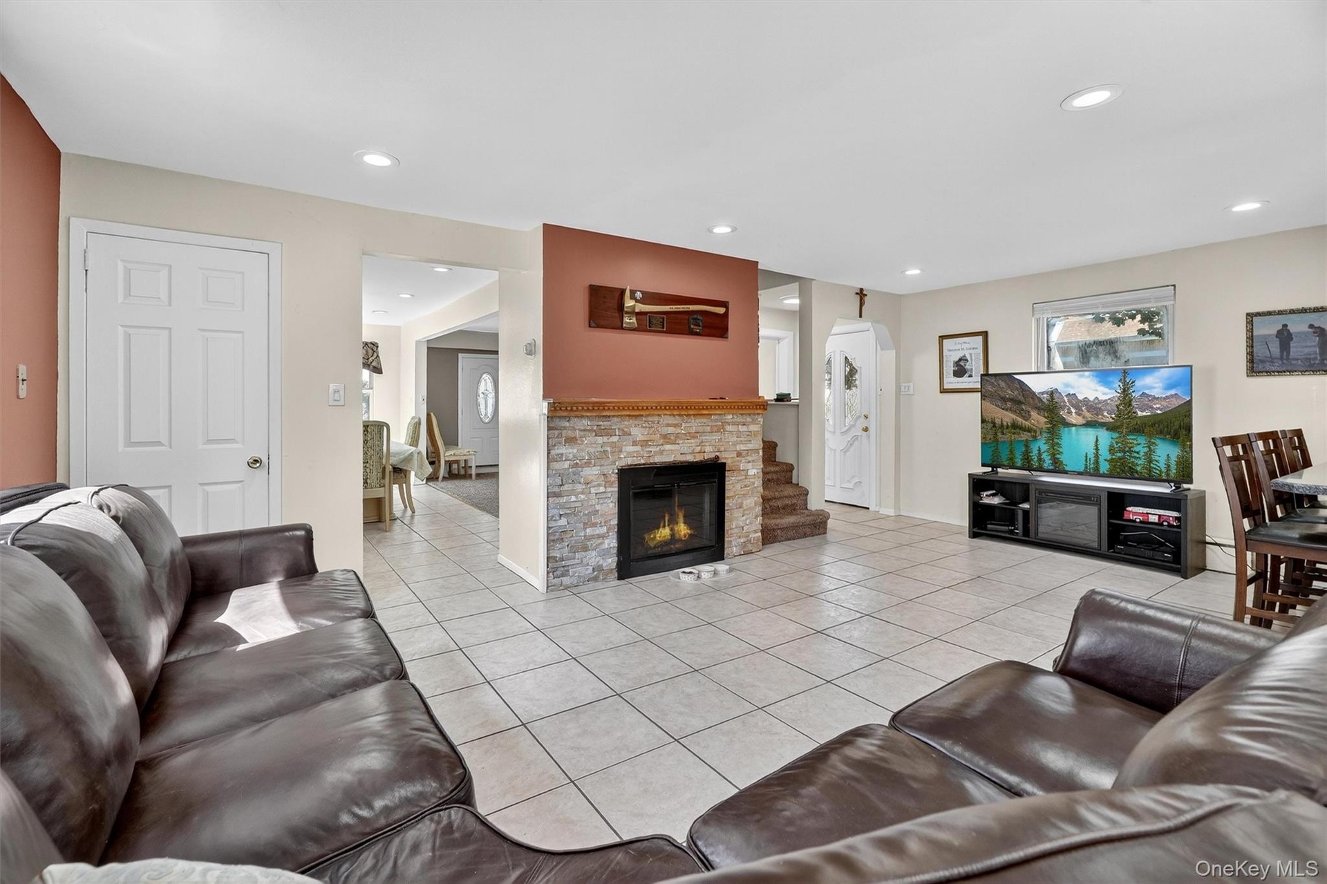 Living area featuring light tile patterned floors, recessed lighting, and a fireplace