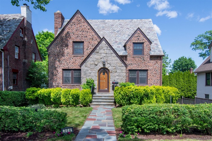 Impressive brick and stone Tudor with slate roof and elegant curb appeal