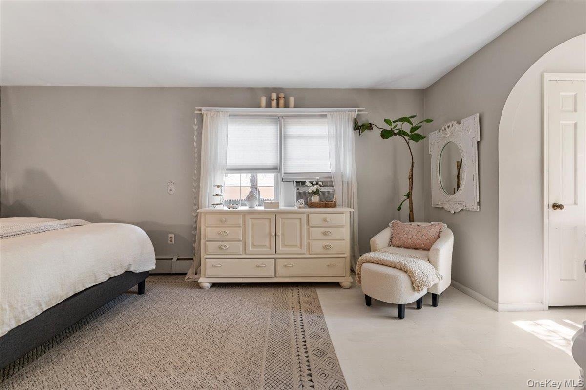Spacious room featuring neutral painted walls and a light-toned area rug over a lighter floor