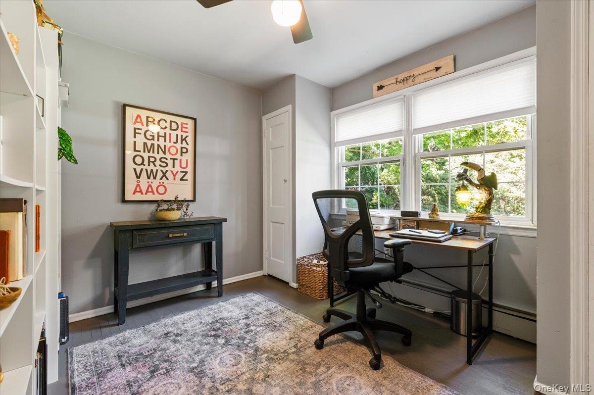 Dedicated room featuring dark wood-finish flooring, white built-in shelving, and light gray wall paint