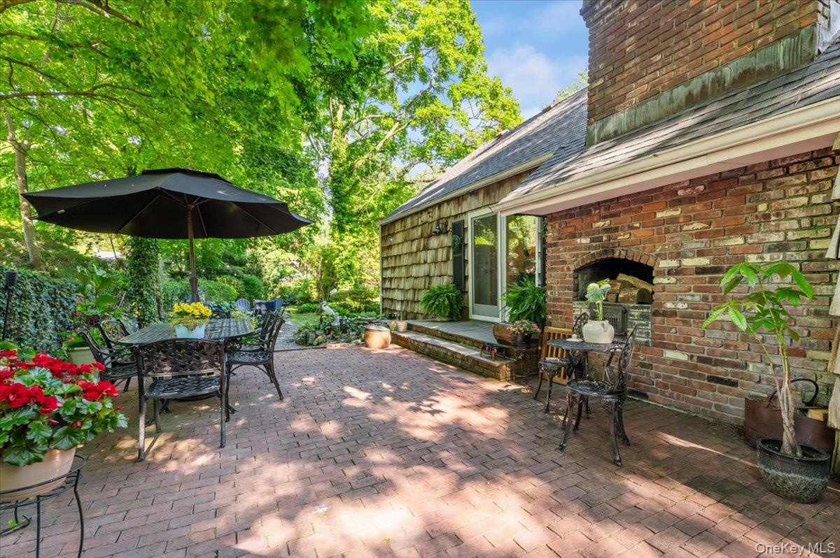Brick patio featuring a built-in outdoor fireplace