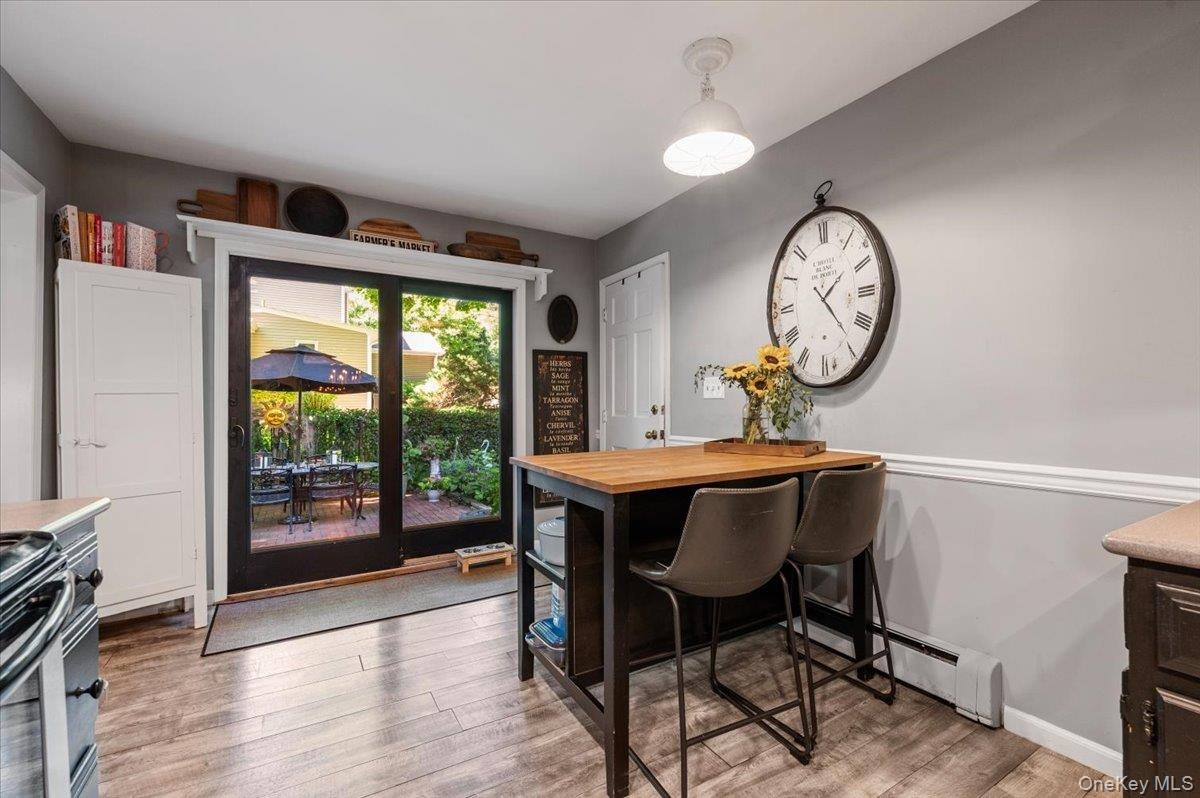 Kitchen area featuring wood-finish flooring, a built-in island with a wood countertop, and sliding glass doors providing access to an outdoor patio sp