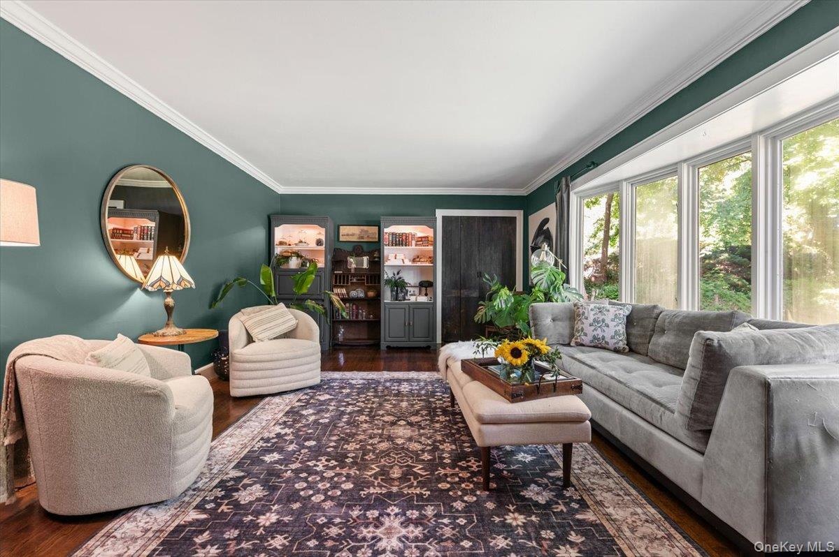 Living area featuring hardwood flooring and a large bay window