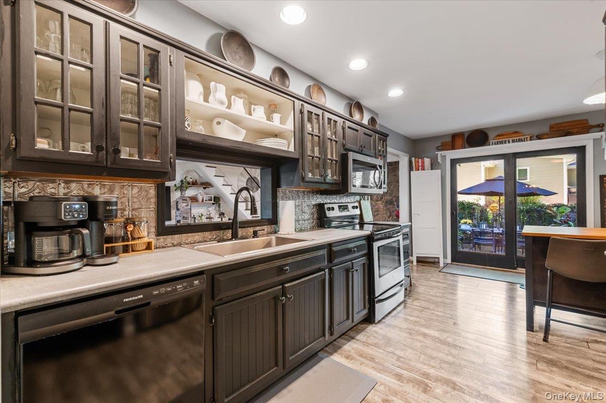 Kitchen featuring dark cabinetry, recessed lighting, and wood-finish flooring