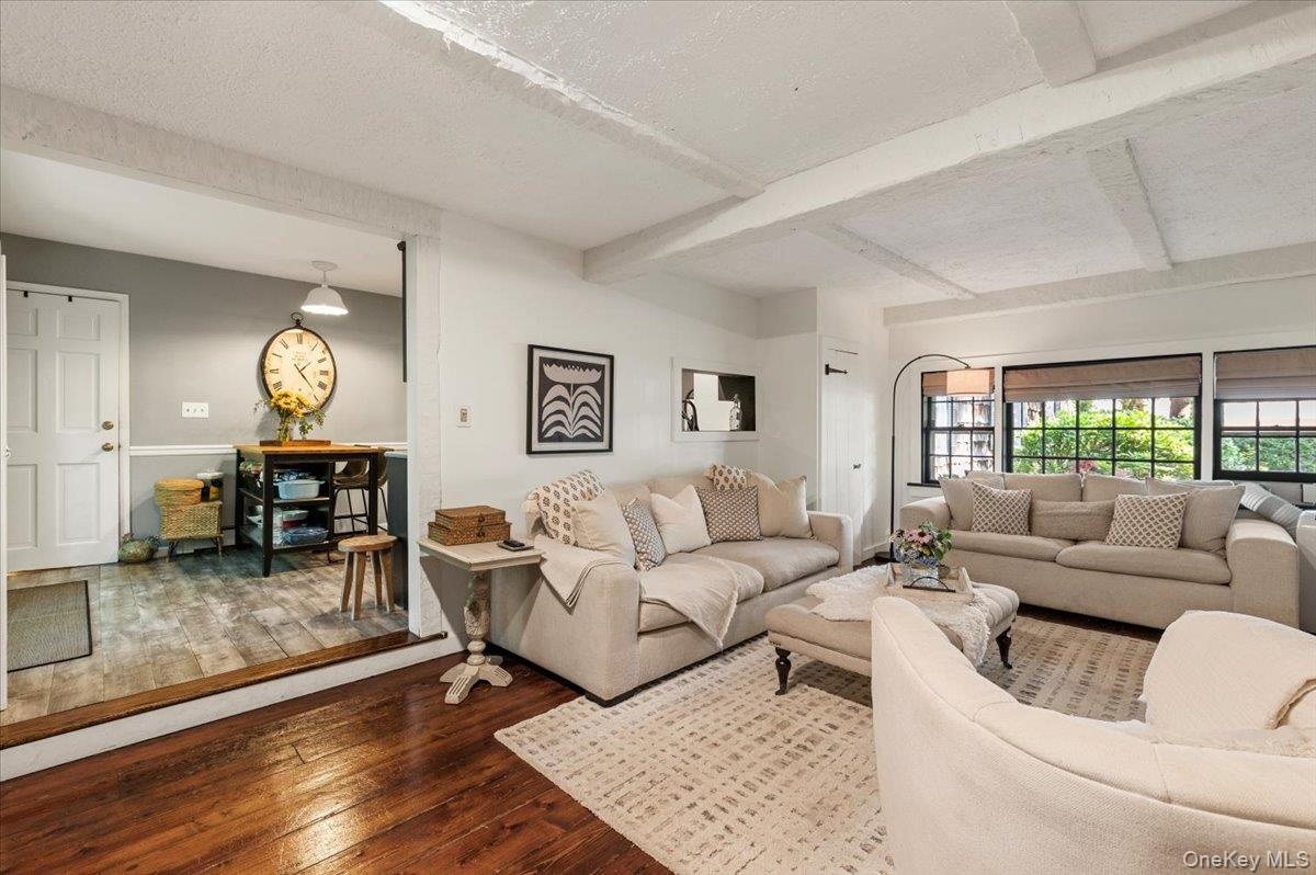 Living room with exposed ceiling beams and dark wood-finish flooring