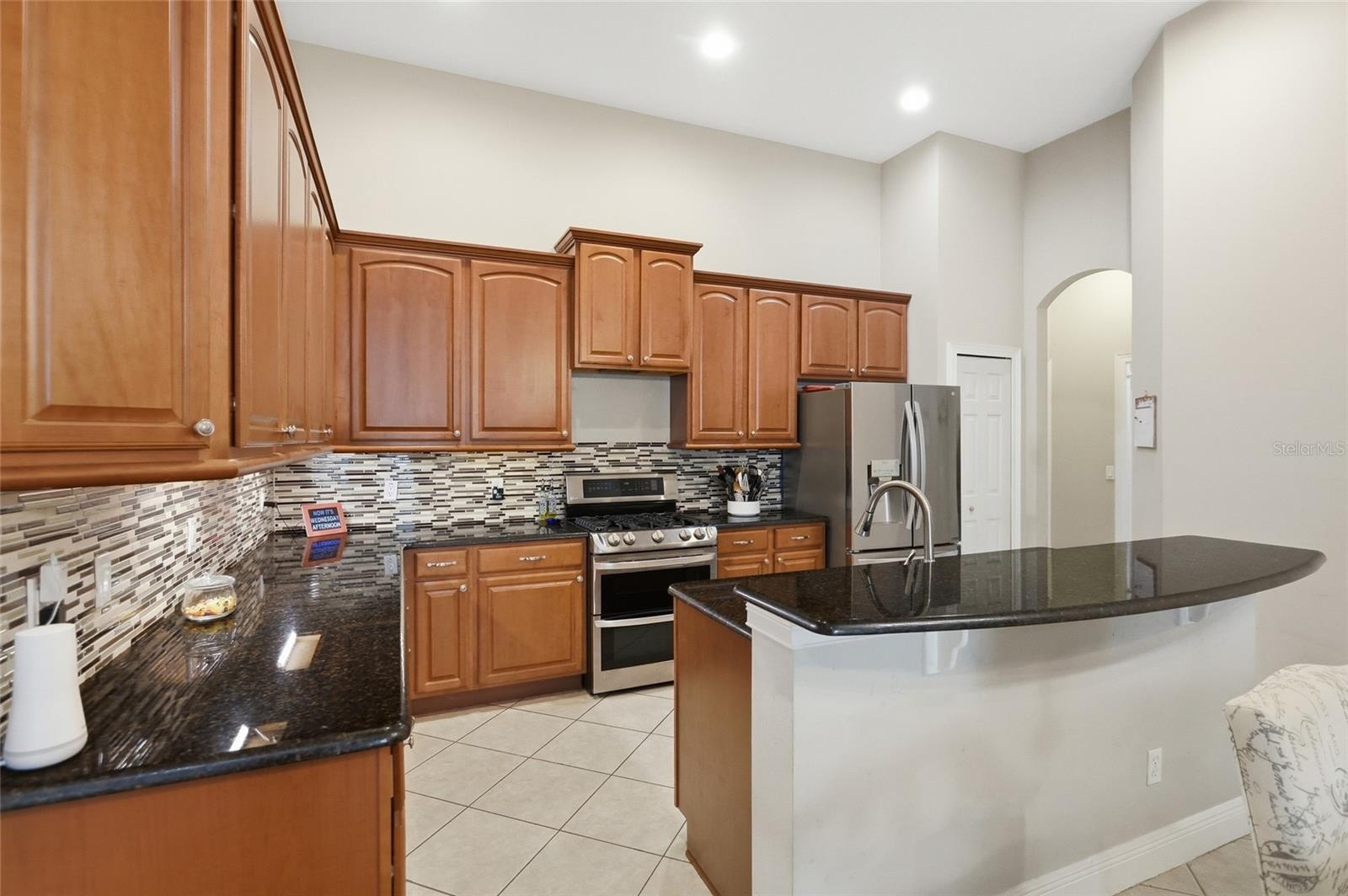 Granite counters, tiled backsplash and breakfast bar featured in the kitchen
