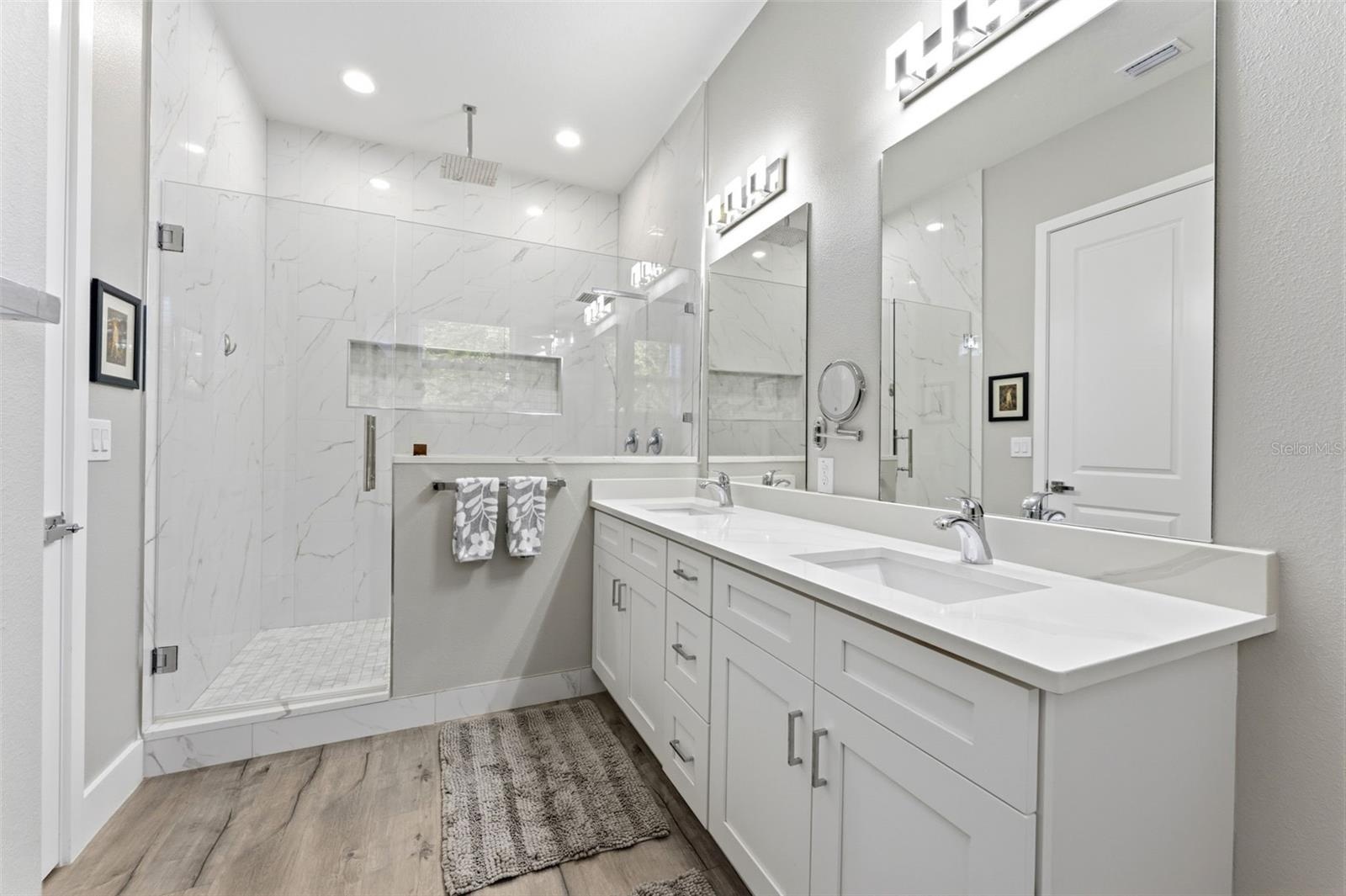 Large Primary Ensuite Bathroom with a double vanity and a large walk-in shower with frameless glass door and rainfall showerhead