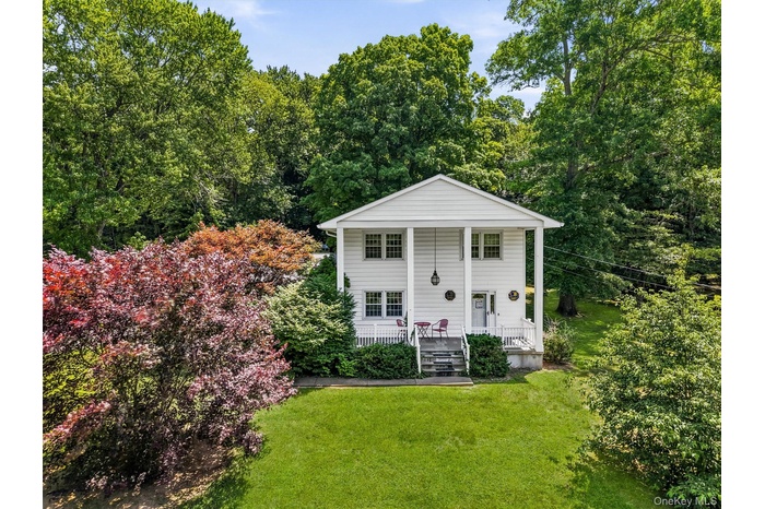 Two-story residence featuring a classic white facade, columned porch, and multiple windows