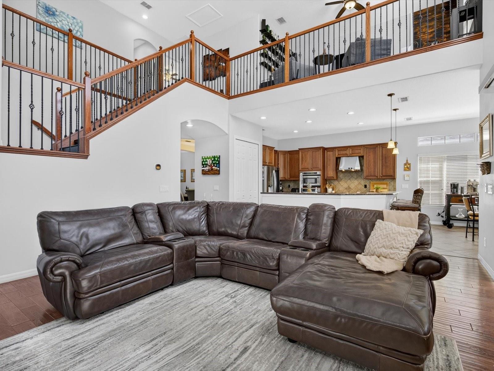 Family room with view into the kitchen and cafe. Loft is observed overhead.