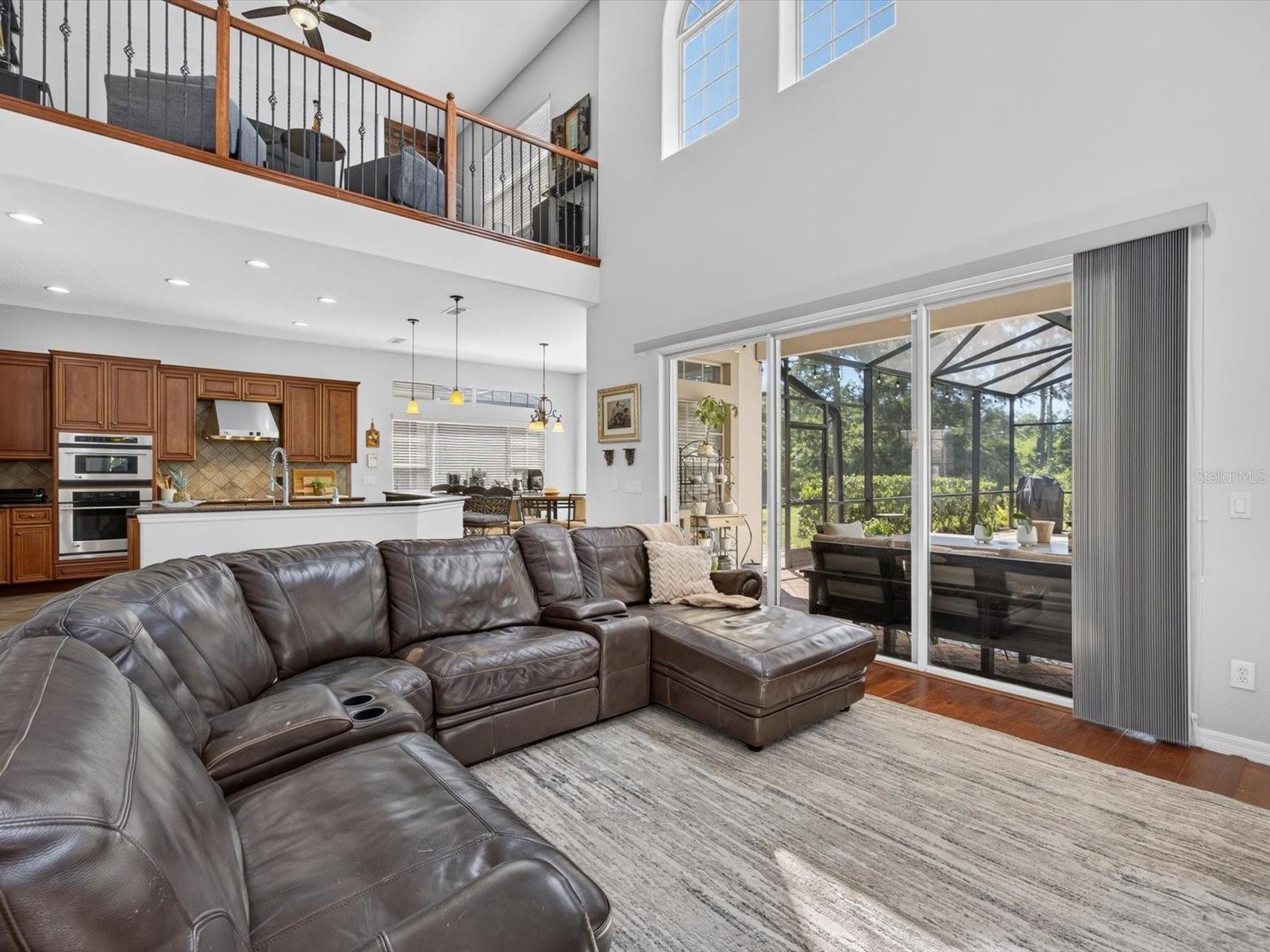 Family room with view into the kitchen and cafe. Loft is observed overhead.