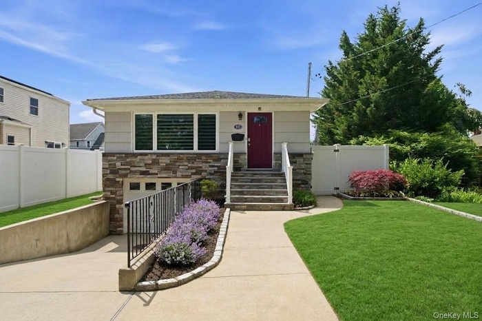 Single-story residence with beautiful curb featuring a stone facade and white siding
