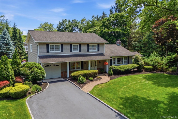 Classic four bedroom colonial with timeless curb appeal, set on a beautifully landscaped property.