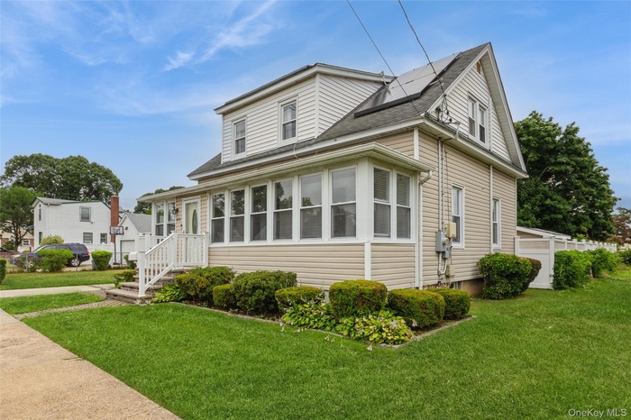 Two-story siding exterior with a front sunroom, a covered porch, and a side entrance