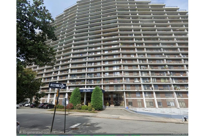 High-rise residential building featuring a terraced facade, individual balconies, brick exterior accents, and a covered entrance